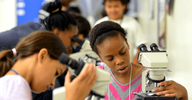 A few young people looking into microscopes