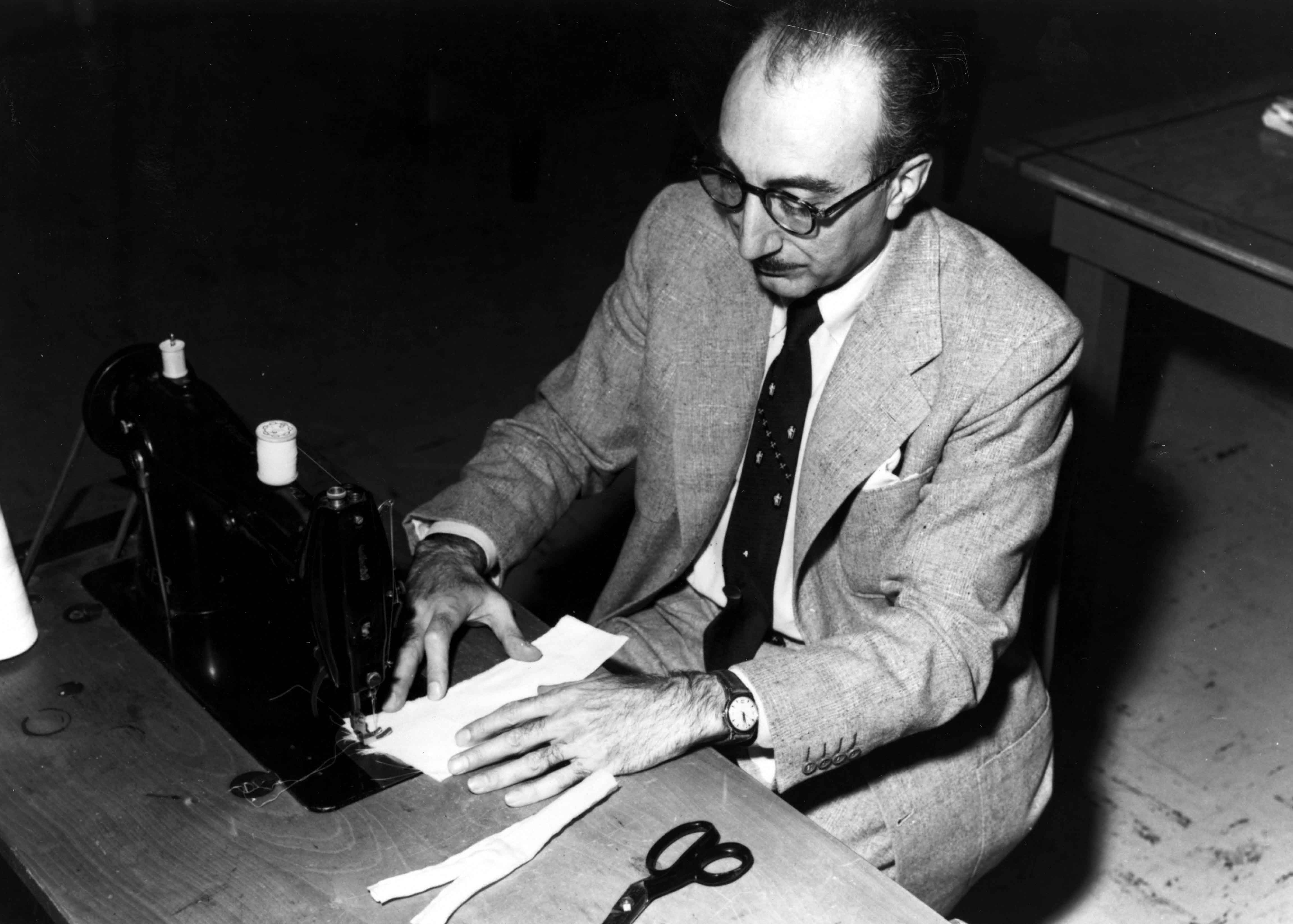 Dr. Michael E. DeBakey sits at his wife's sewing machine fashioning the first artificial arteries for cardiac bypass surgery made of Dacron. Image courtesy Baylor College of Medicine Archives.