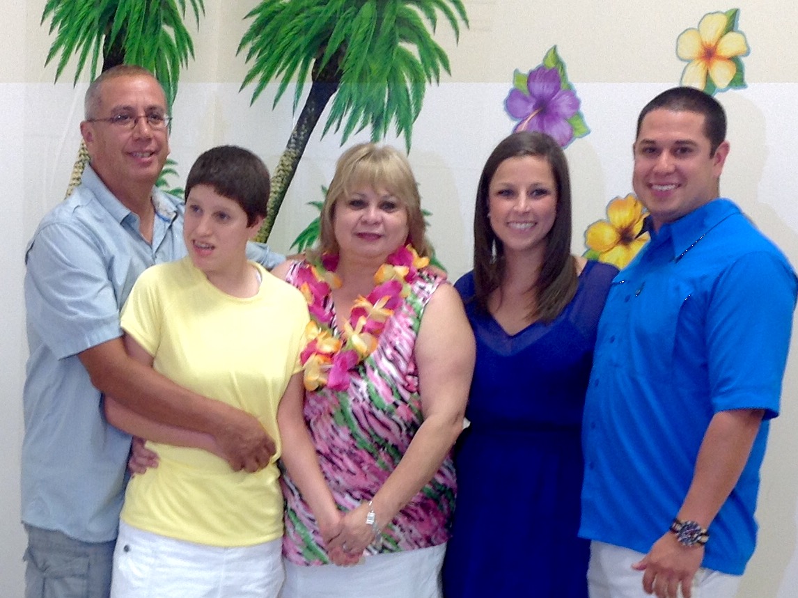 The Guerrero family. Viola and Gene Guerrero stand on either side of  Gina in yellow. Son Michael  and daughter-in-law Kerryann are to the right.