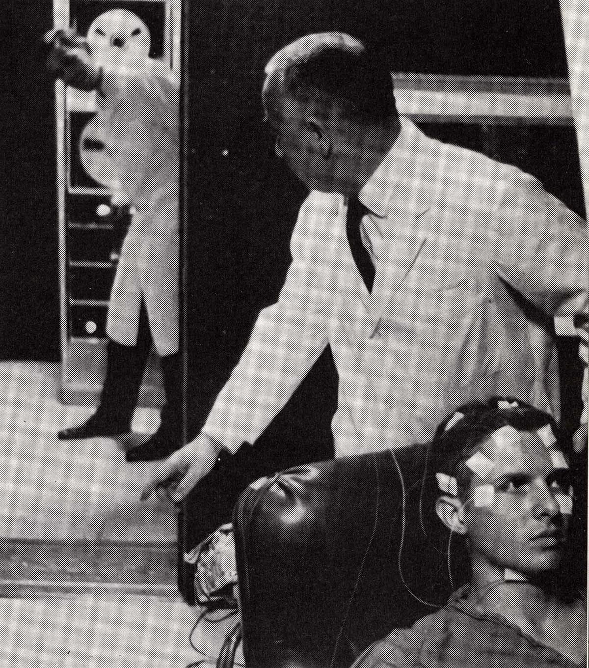 A doctor comes around the corner to find his colleague putting a patient through an Electroencephalography (EEG) test