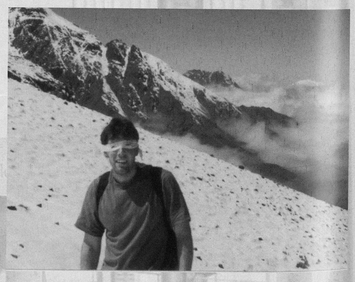 A man in a makeshift mask standingg high up on a mountain. Courtesy of the Baylor College of Medicine Archives