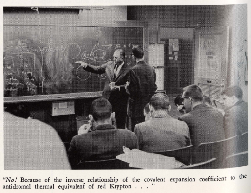 A lecturer gestures to a student to view a complicated equation on a chalkboard.