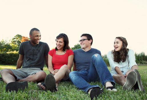 smiling-teens-sitting-on-green-grass