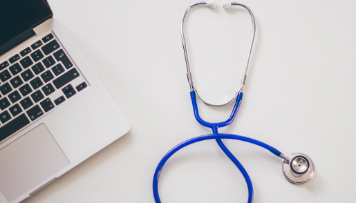 A stethoscope sitting next to a laptop