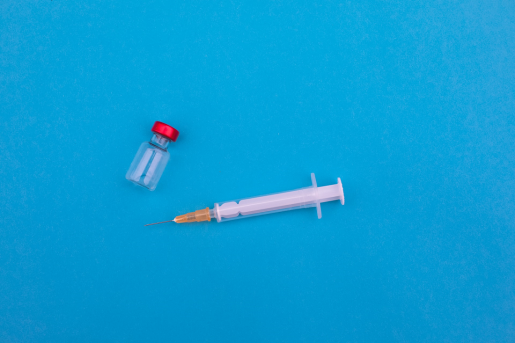 needle-vaccine-blue-background