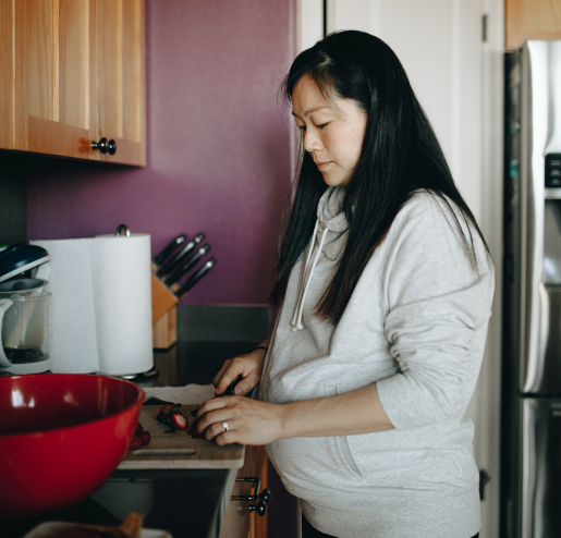A pregnant person cooking a healthy meal