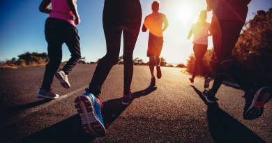 A group of people running toward the rising sun.