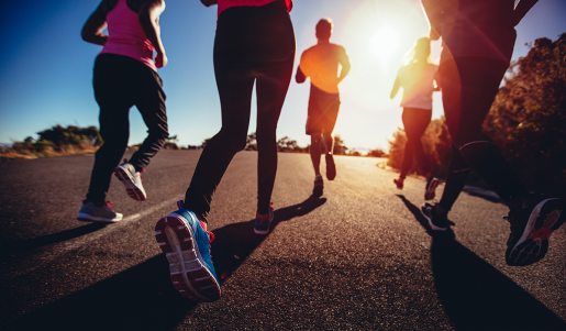 A group of people running toward the rising sun.