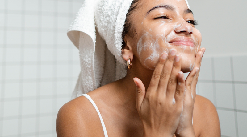 A person cleaning their face with skincare products after a shower