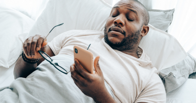 A person settling into bed while looking at their phone