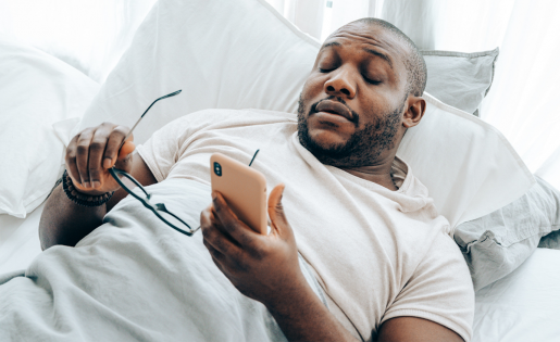 A person settling into bed while looking at their phone