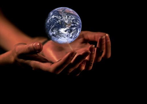 A digital image showing the planet Earth being held above a pair of human hands