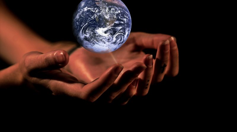 A digital image showing the planet Earth being held above a pair of human hands