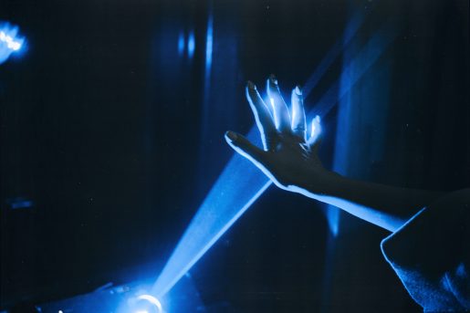 A dark room, with light streaming out of a projector onto a person's hand