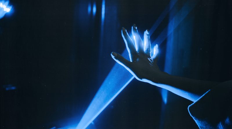 A dark room, with light streaming out of a projector onto a person's hand