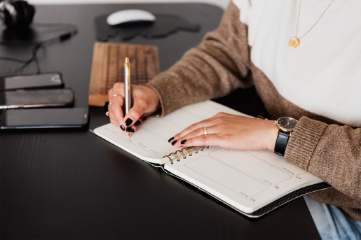 A person filling out their day planning calendar with social events.