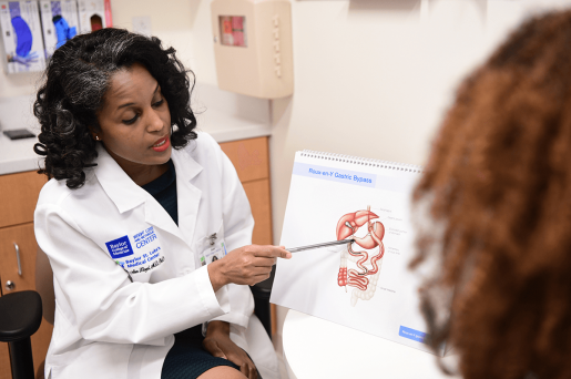 A bariatric surgeon uses a diagram of the human body to consult with a patient about the benefits of bariatric surgery.