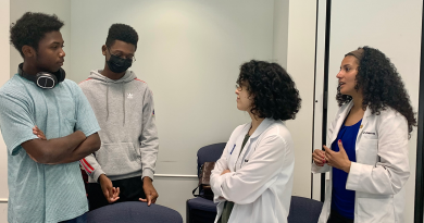 Baylor students and two young men chat during the Future Doctor's Camp.