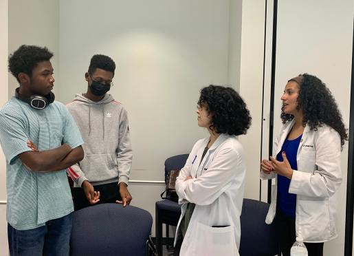 Baylor students and two young men chat during the Future Doctor's Camp.