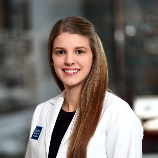 A picture of Ashley Waldon. A woman with light brown hair in a white lab coat.