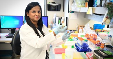 Dr. Debosmita Sardar smiling at the camera while using research test supplies.