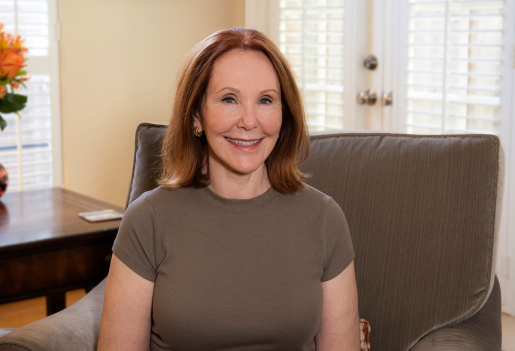 Judy Howell, smiling while sitting in her living room