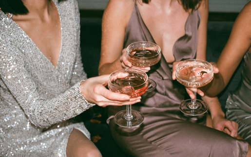 Three people in fancy dress clinking champagne glasses together.