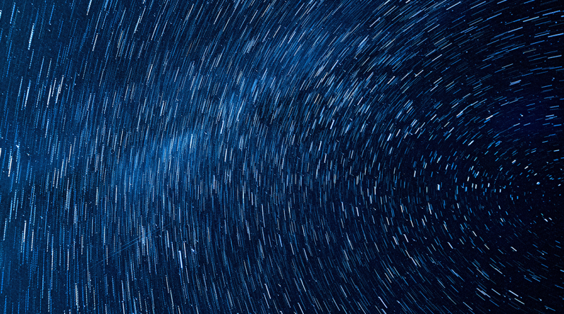 Stars in motion streaking across the dark sky.