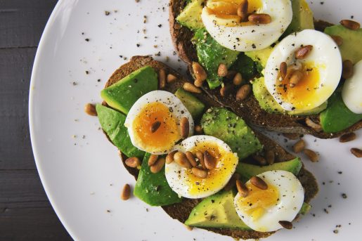 Toast with bright green avocado slices and halved par-boiled eggs.
