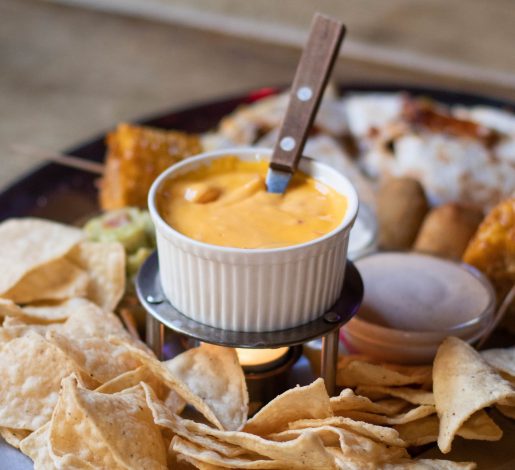 Snacks on a table. Items include chips and queso, fried items and more.