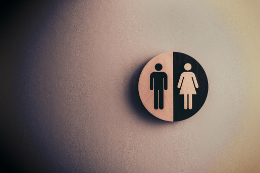 A sign on a wall indicating men's and women's bathroom.