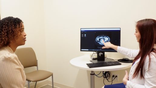 A doctor pointing something out to a patient on a pelvic x-ray.