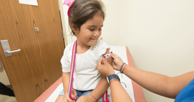 A child having an adhesive bandage applied to their arm after a shot