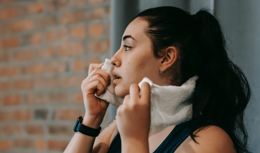 A person wiping away sweat with a towel.