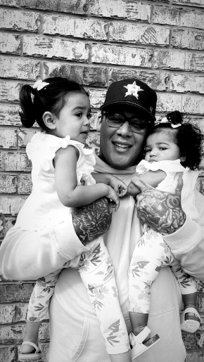 Michael Cartagena holding his two young children in his arms