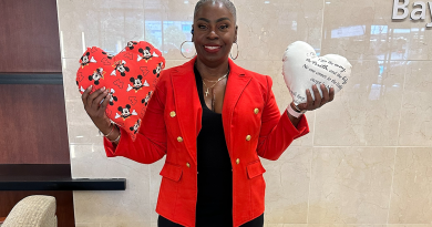 Minnie Booker holding up two heart-shaped pillows