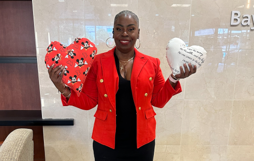 Minnie Booker holding up two heart-shaped pillows