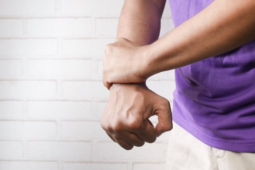 Close up of person holding wrist in pain.