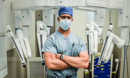Dr. Shawn Groth stands in front of his robotic surgery device.