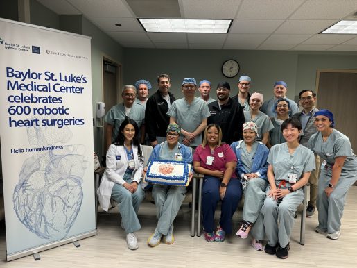 Dr. Kenneth Liao and surgery team posing for a photo with a cake as they celebrate the 600th robotic surgery.