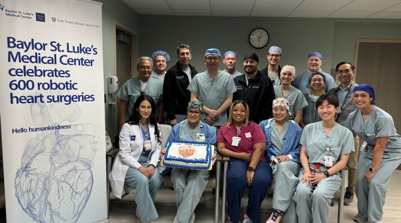 Dr. Kenneth Liao and surgery team posing for a photo with a cake as they celebrate the 600th robotic surgery.