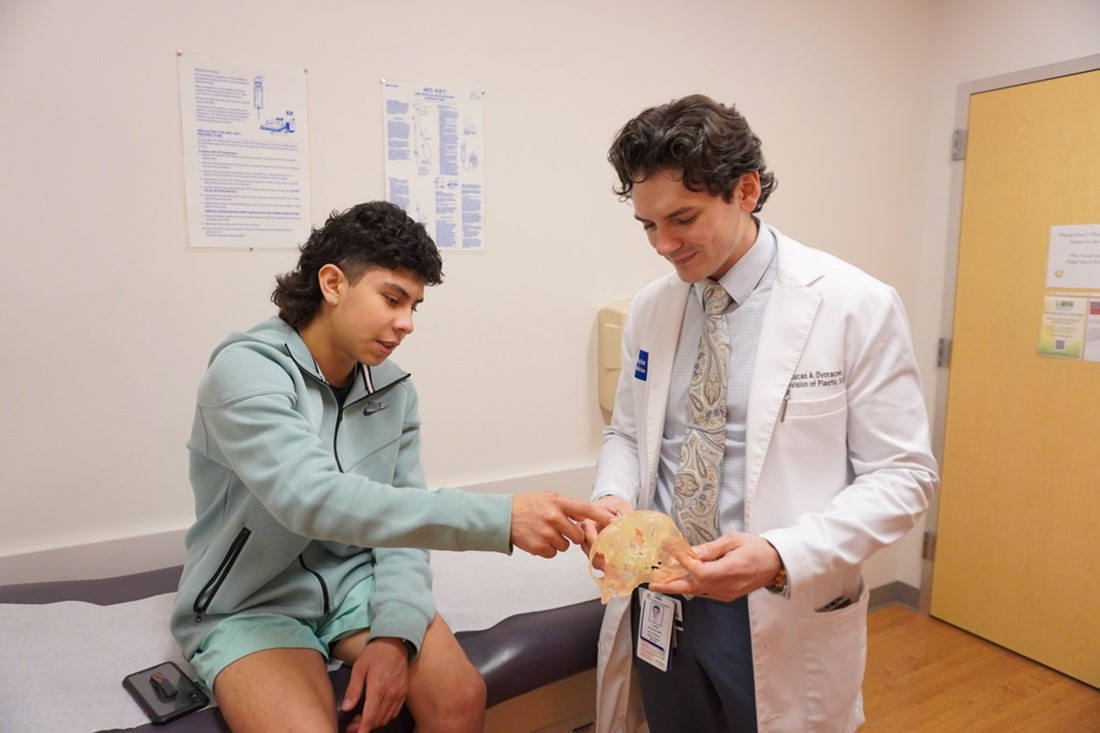 Aaron Silva inspecting a 3D model of the fractures in his face with Dr. Lucas Dvoracek.