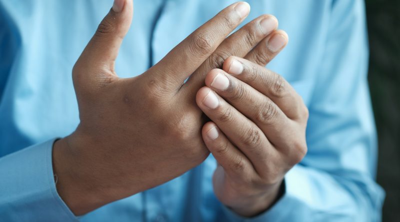 A person holding their fingers as if they are in pain.