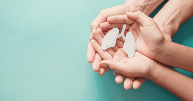 A set of hands holding a small paper cutout of lungs.