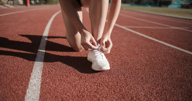 A person on a sprinting track tying their shoes