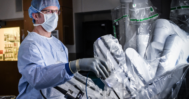 A surgeon in an operating room manipulating the controls for a robotic surgery device.