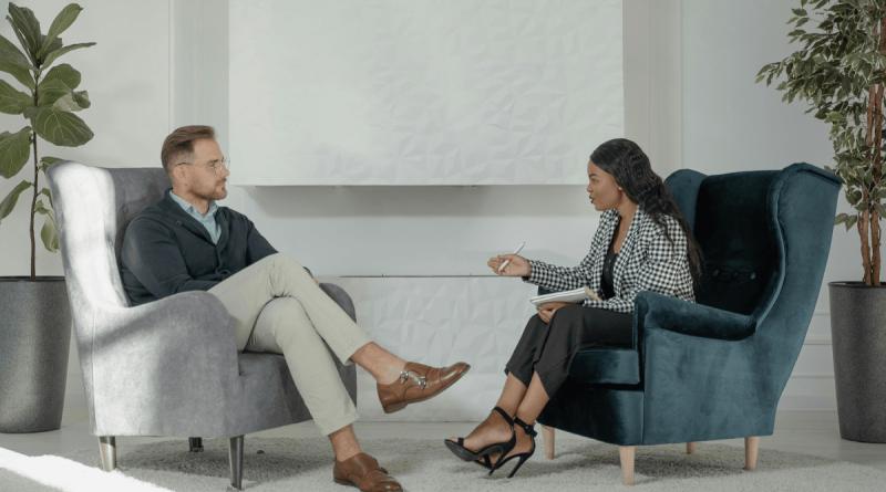 A doctor and patient speak during a therapy session.