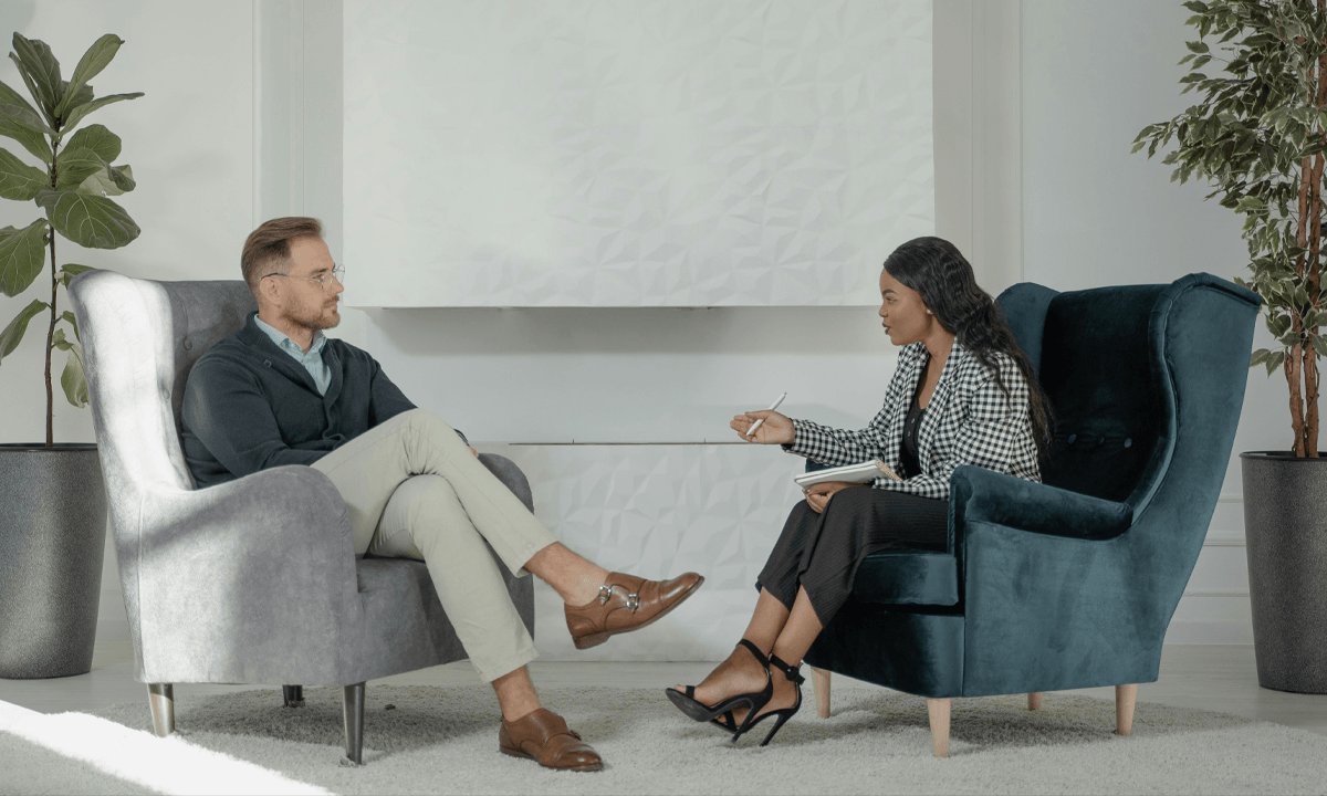 A doctor and patient speak during a therapy session.