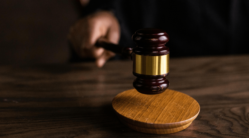 A hand bringing a gavel down onto a sound block.