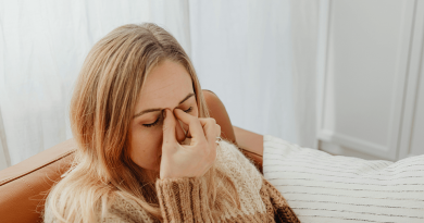 A person pinching the bridge of their nose in pain.